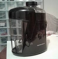 Photo of the side view of the black Hamilton Beach juicer showing the pulp container and feeding chute.