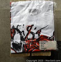 Folded white Marvel T-shirt with visible Venom graphic, sealed in plastic packaging with a size and product label.