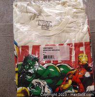 New Marvel branded t-shirt in original packaging showing colorful graphic of Marvel characters including Hulk and Iron Man.