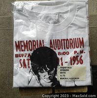 White packaged Elvis Presley t-shirt folded to show front print with event details and image on Memorial Auditorium concert dated 1956.