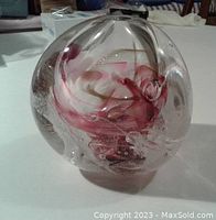 Front angle showing clear glass dome with internal gold, purple, and pink swirls and air bubble details