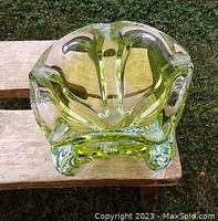 Top down view showing the interior floral/star-shaped opening and thick clear-to-yellow-green glass walls.