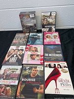 Photo showing 10 individual DVD movies arranged in 2 rows on black cloth.