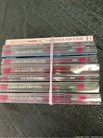 Stack of Sex and the City seasons DVDs labeled 1 through 6 with two copies of season 6, from HBO