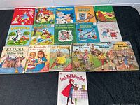 Top view of all 17 vintage kids books laid out in four rows, showing titles and colorful illustrated covers.