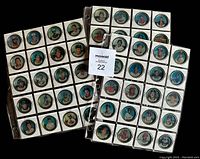 Front side of the 1987 Topps baseball metal coins showing colored player portraits in round coin format in binder pages.