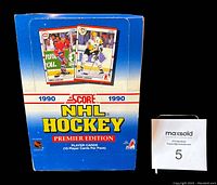 Front-right angle of the sealed blue and white Score 1990 NHL Hockey Premier Edition wax box with player card images on it.