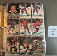 Photo of binder page displaying nine hockey cards with players from the 1991-92 NHL season in action and posed shots.