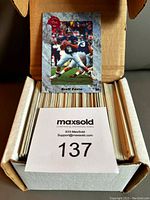 Photo showing a white storage box with a large number of trading cards and the Brett Favre rookie card placed on top.