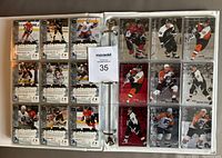 Photo of binder pages with hockey cards inserted, showing players in action poses.