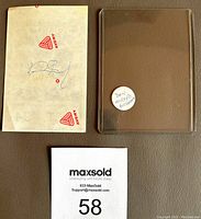 Photo showing the signed Avery paper with protective brown sleeve and label indicating the item's content.