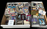 Photo of a large box filled with thousands of baseball cards, some loose and some in protective sleeves, spanning 1985-1994 era.