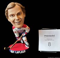 Front view of Guy Lafleur bobblehead doll showing detailed facial features, red base with name, and hockey uniform.