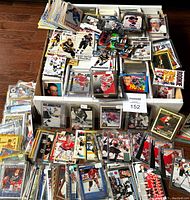 Large overflowing storage box filled with thousands of 1990-1995 hockey cards, many sleeved and some in top loaders
