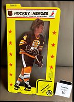 Front view of sealed Bobby Orr Hockey Heroes standup in original yellow packaging with item visible inside.