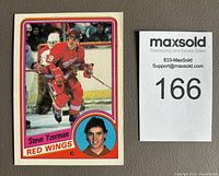 Front view of Steve Yzerman 1984-85 OPC rookie card #67 in Red Wings uniform next to auction lot number.