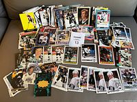 Photo showing a large spread of Wayne Gretzky hockey cards with various images and designs including several cards in protective sleeves.