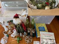 Lot contents including ornaments, figurines, glass bottles, ribboned box, songbooks displayed on floor and table.