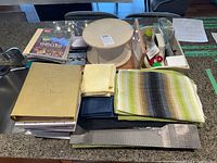 Overall kitchen counter photo showing cookbooks, placemats, wooden turntable, and kitchen utensils grouped