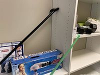 Photo showing Dr. Ho Neck Pain Pro device box and some black dumbbell weights on a shelf
