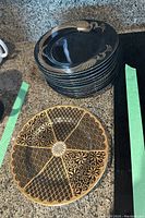 Stack of plates showing the side view with black and gold pattern around the rim.