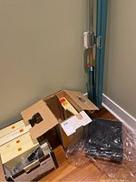 Boxed Kodak slide carousels and folded blue-framed projector screen on floor