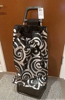 Rolser shopping hand cart front with black and silver swirl patterned tote bag, showing handle and drawstring closure.