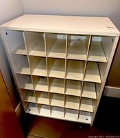 Front view of white storage unit showing 20 cubby compartments in 4 rows and 5 columns.