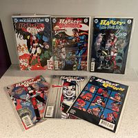 Top-down image showing six different Harley Quinn comic books, including numbered issues and titles such as DC Universe Rebirth and Harley's Little Black Book.