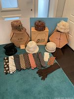 Full lot overview showing all hats, original boxes, ties, and gloves arranged on floor