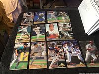 Image showing 13 different 1994 Fleer baseball cards arranged on a dark surface displaying players including Sosa, Larkin, and others.