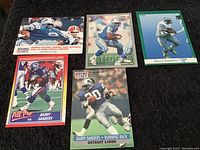 Photo of five Barry Sanders collectible football cards showing different action images and card designs in excellent condition.