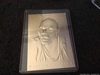 Front side of Hakeem Olajuwon 1993-94 embossed collectible basketball card showing raised metallic image of player from shoulders up in jersey.