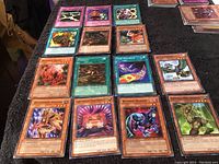 Photo showing 20 Konami vintage collectible cards spread on a black surface. Includes Monster and Spell cards with colorful designs.