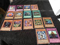 Lot of 20 Konami Yu-Gi-Oh collectible cards laid out on a dark cloth, showing monster, spell and trap cards.