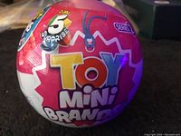 Photo of Zuru Toy Mini Brands Series 2 spherical packaging showing '5 Surprise' and branding graphics.