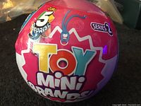 Front view of the pink spherical package showing brand name 'Toy Mini Brands' and 'Series 2' with indication of 5 surprise mini toys inside.