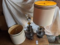 Two black porcelain lamp bases; one shade on and one shade off to show both bases and shade design