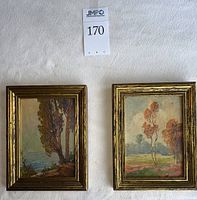 Two framed oil paintings side by side showing seascape and meadow landscapes with lot sign visible
