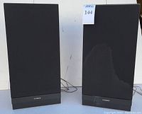 Pair of upright rectangular Fisher MS-108 speakers with black fabric grille covers. One speaker shows visible discoloration on the fabric. Both have black bases with Fisher branding.