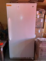 Front view of the GE commercial upright freezer showing the full door, handle, and lock.