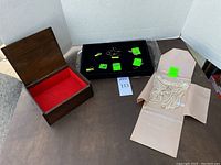 Overview of wooden box, tray with gold jewelry and pearl necklace set on table