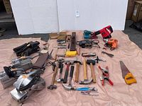 Wider view of all tools laid out including power and hand tools showing condition and variety.