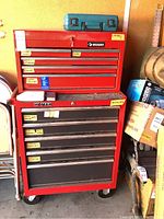Front view of assembled red Husky top tool chest and Homak rolling bottom cabinet on casters