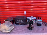 Photo showing the full lot with all items: Jolly Time Corn Popper kettle cooker, GE black fan, GE FM/AM radio, Toastmaster toaster with vinyl cover, and Paymaster Check Writer vinyl cover.