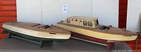 Both wooden boat models displayed on stands