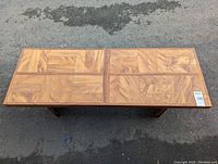 Top view of the coffee table showing the patterned wooden blocks and strips surface.