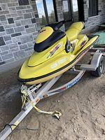 Yellow and black Sea-Doo jet ski mounted on aluminum trailer, side view