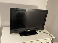 Front view of RCA TV on white dresser for comparison, it is not the lot item.