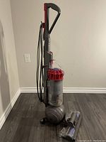 Front view of Dyson Ball upright vacuum cleaner with detachable brush head on floor.
